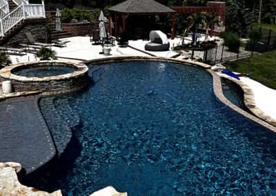 Sparkling custom built in ground pool with spa and tanning shelf