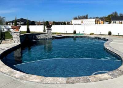 Custom inground pool with fire bowls and basketball hoop